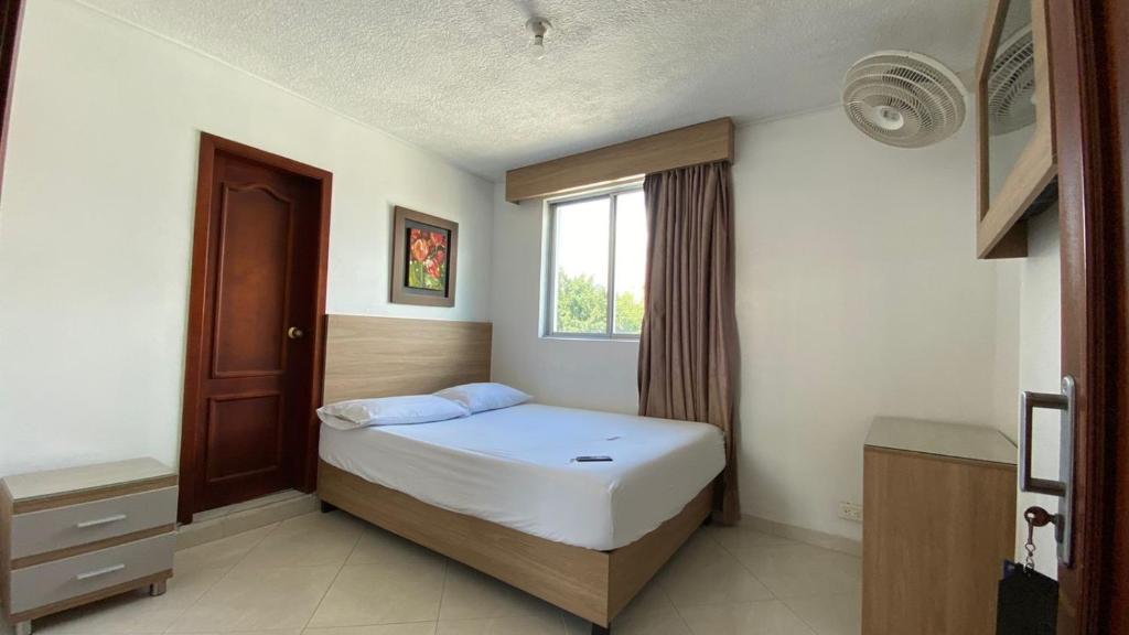 a small bedroom with a bed and a window at HOTEL GUADALUPE BGA in Bucaramanga