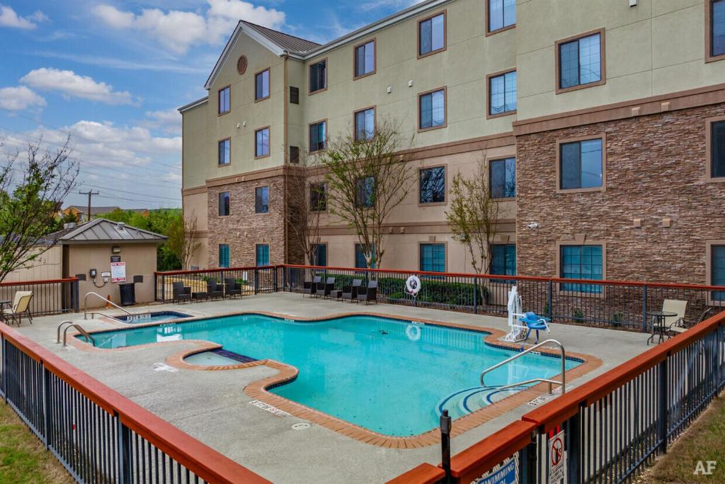 une piscine en face d'un bâtiment dans l'établissement Cozy Apartment by La Cantera & Rim, à San Antonio