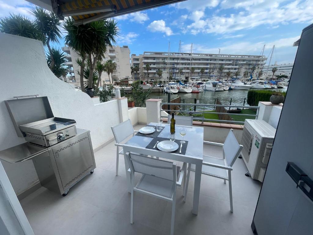 a balcony with a table and chairs and a marina at Apartamento puerto madeira Roses in Roses