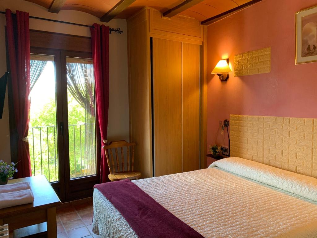 a bedroom with a bed and a sliding glass door at CASA JESUS in Abiego