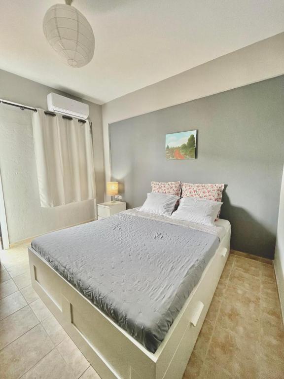 a bedroom with a large bed with white sheets and pink pillows at Souzana Suite Leptokarya in Leptokarya