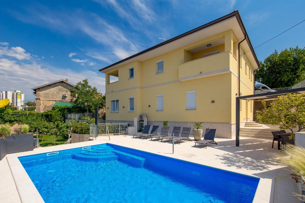 a swimming pool in front of a house at Apartmants Belvedere Rijeka in Rijeka