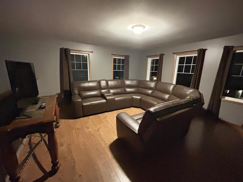 Betula Lake Resort في Seven Sister Falls: غرفة معيشة مع أريكة جلدية وطاولة