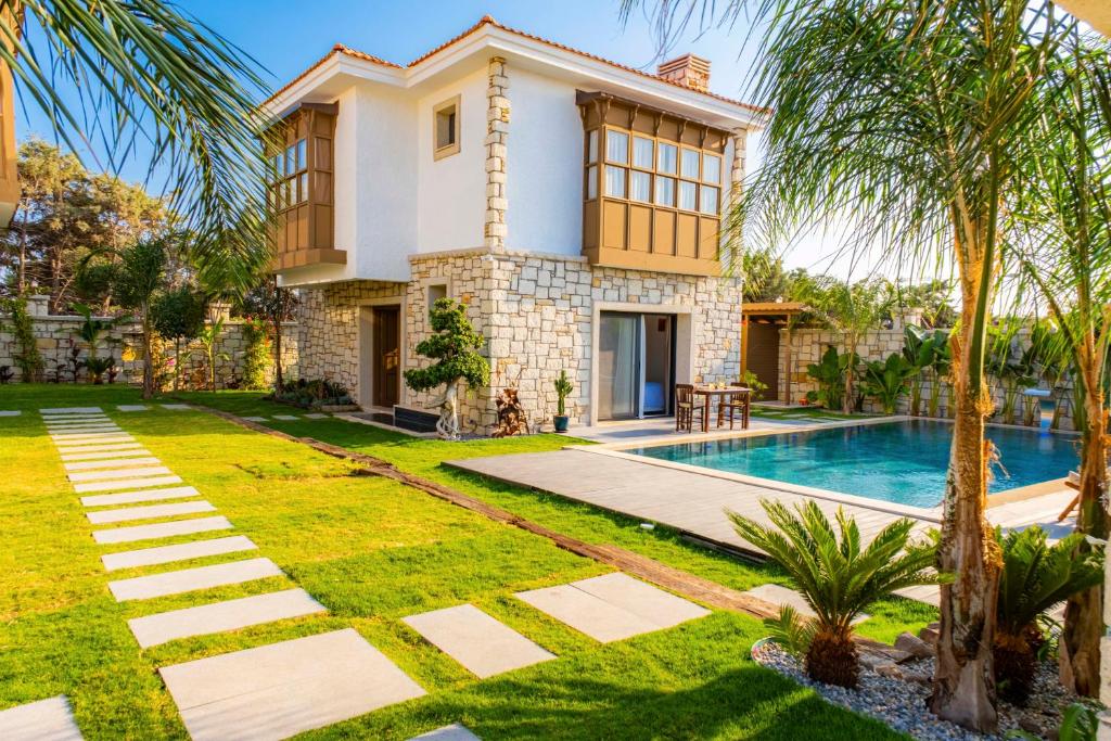 a house with a swimming pool in front of it at Marrakesh Alaçatı in Ildır