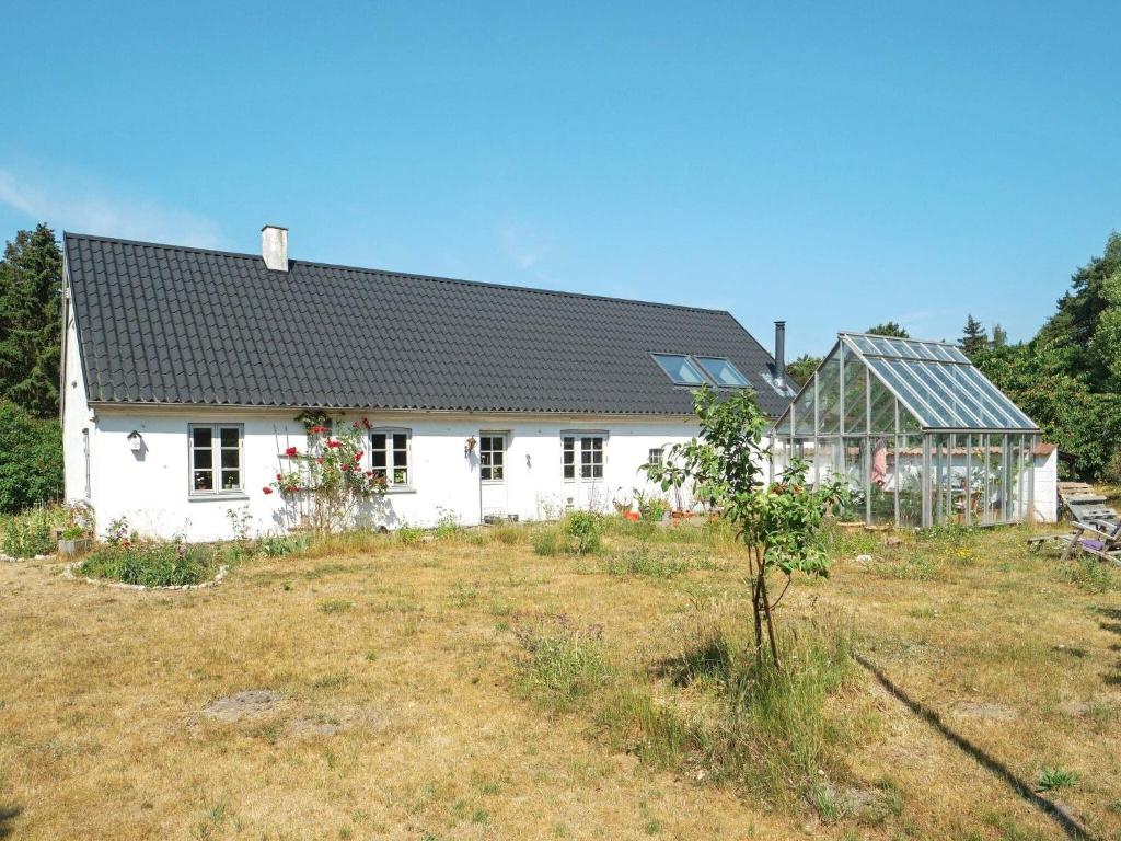 une maison blanche avec un jardin en face dans l'établissement 5 person holiday home in H jby, à Højby