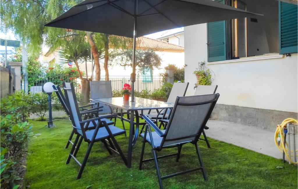 uma mesa e cadeiras com um guarda-sol num quintal em 3 Bedroom Lovely Apartment In Tortoreto Lido em Tortoreto Lido