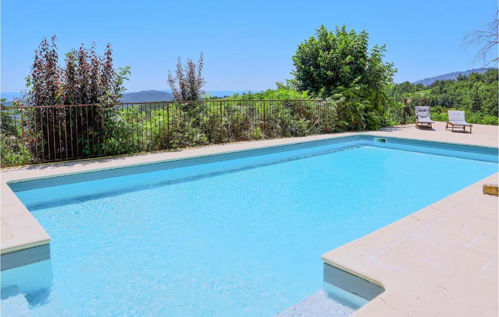 una piscina de agua azul frente a una valla en 1 Bedroom Amazing Home In Mercuer, en Mercuer