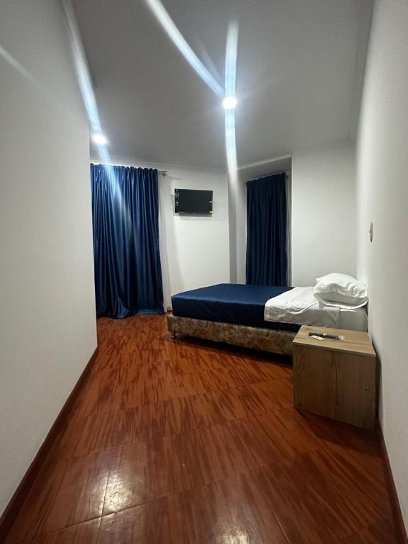 a room with a bed and a wooden floor at Hotel Artistico in Bogotá