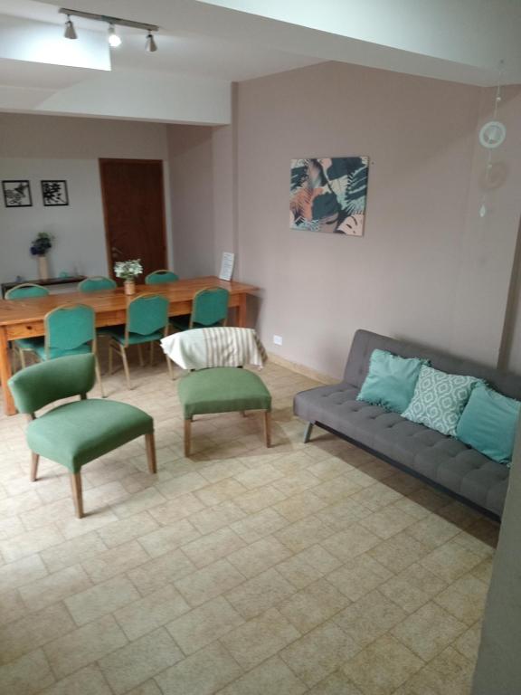 sala de estar con sofá, sillas y mesa en Casa pura vida en General Roca