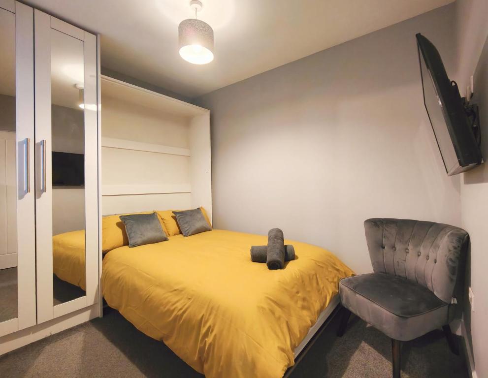 una camera con letto giallo e sedia di Cosy Holiday Home in Hazel Grove - Self Catering Apartment 1 a Hazel Grove