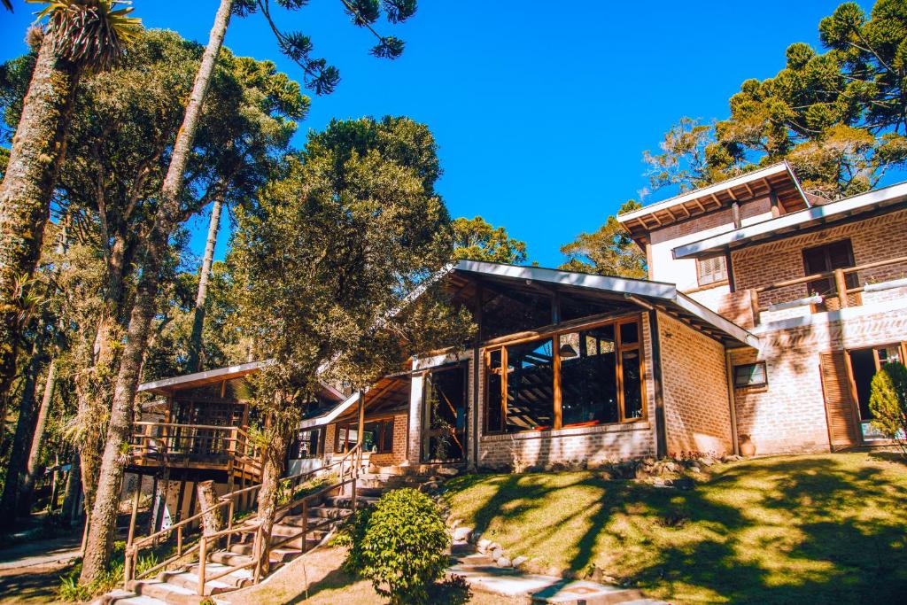 an exterior view of a house with trees at Pousada Villa Serena in Campos do Jordão