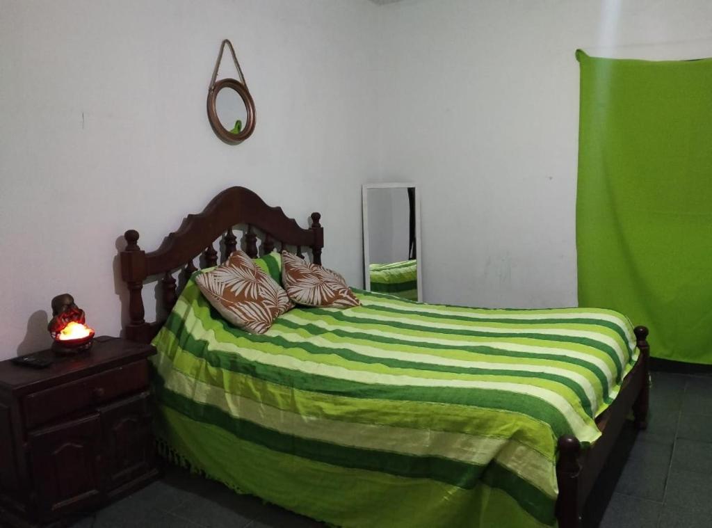 a bedroom with a bed with a green blanket at Doña Chicha in Tinogasta