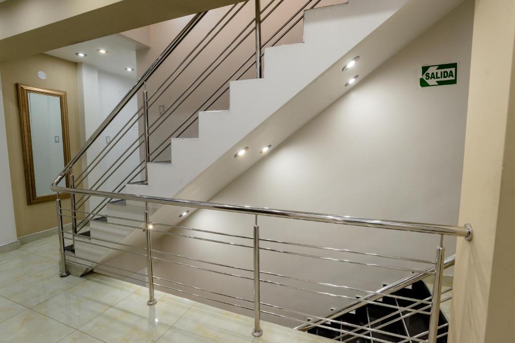 a staircase with stainless steel railings and a glass railing at Hotel Melthon Class in Ayacucho