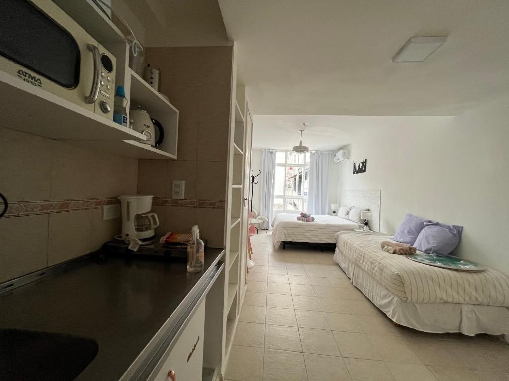 Habitación pequeña con 2 camas y cocina en Clover Apartment Studio en Buenos Aires