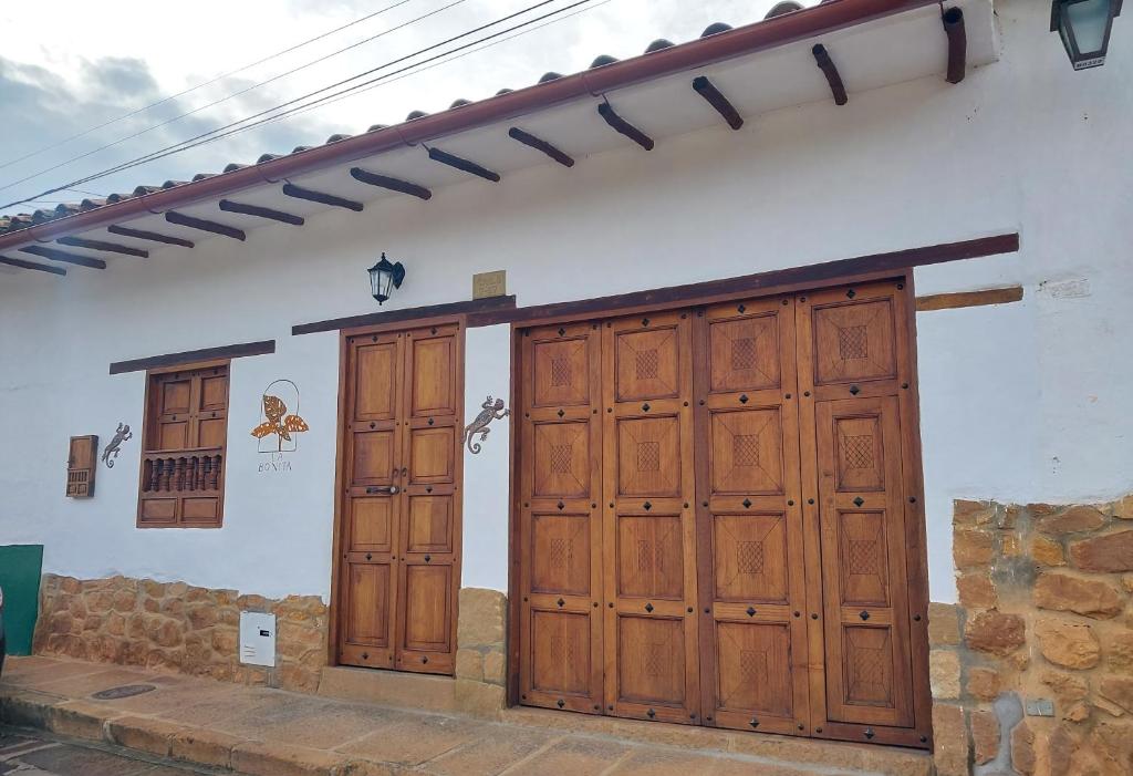 Casa La Bonita - Barichara في باريكارا: بابين خشبيين على جانب مبنى