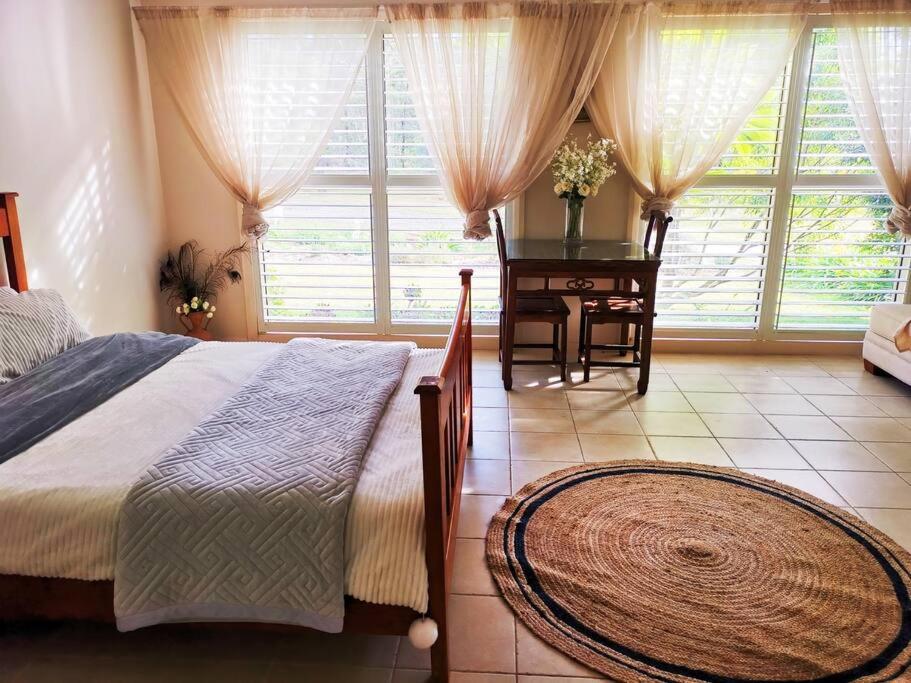 a bedroom with a bed and a table and windows at wonderwander -the whole farm house in Ravensfield