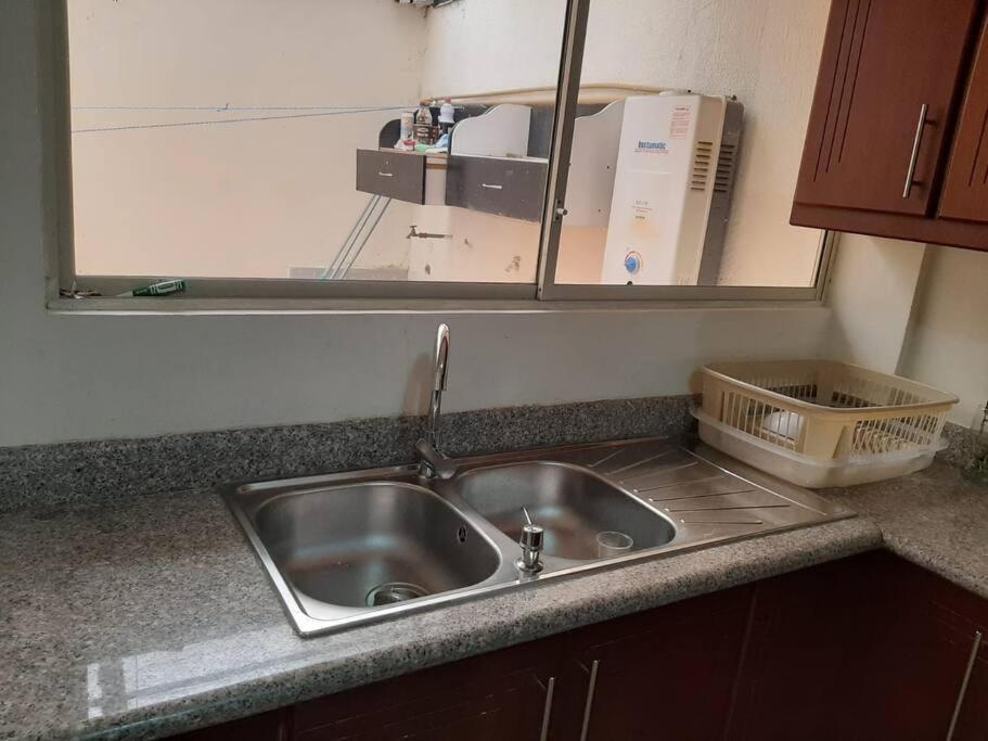 - un lavabo dans la cuisine avec un miroir au-dessus dans l'établissement Andaluz Townhouse for Rent, à Loja