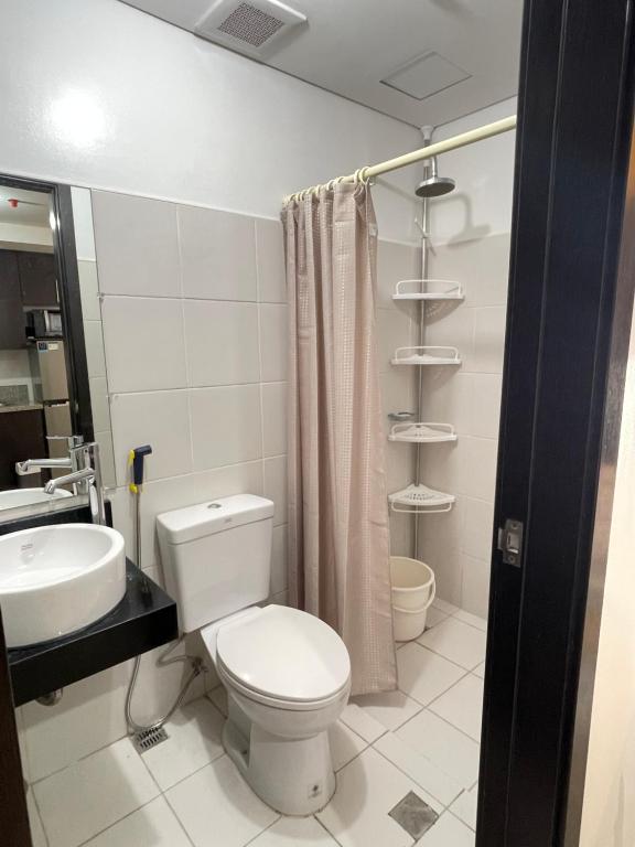 a bathroom with a toilet and a sink at 2-bedroom Condo Unit in Manila