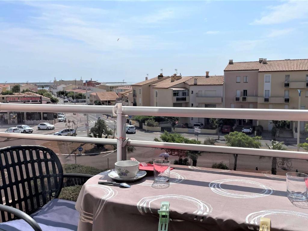 une table sur un balcon avec vue sur une ville dans l'établissement Appartement 2 pièces climatisé avec balcons, proche plage et commerces, Port-la-Nouvelle - FR-1-229C-83, à Port-la-Nouvelle