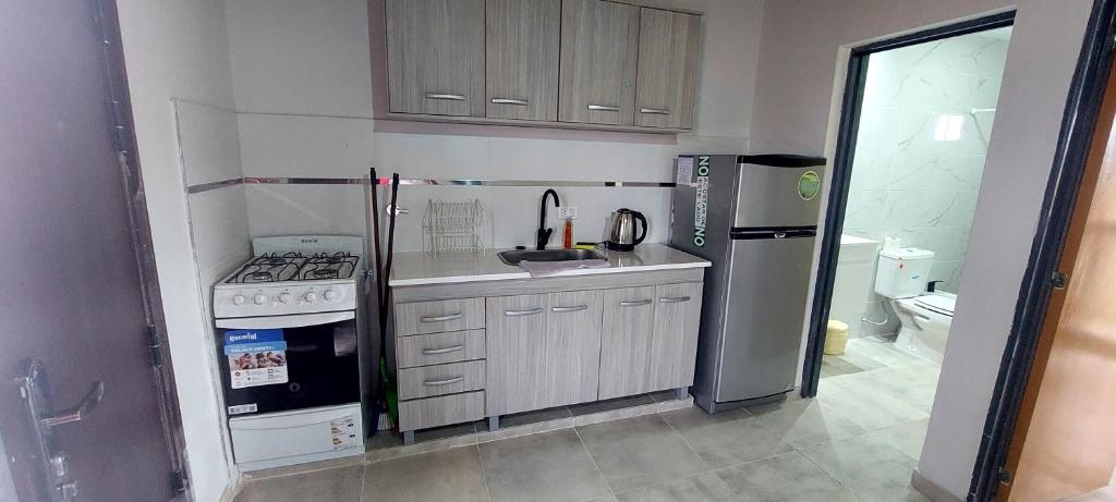 a small kitchen with a stove and a refrigerator at Complejo Las3B in General Roca