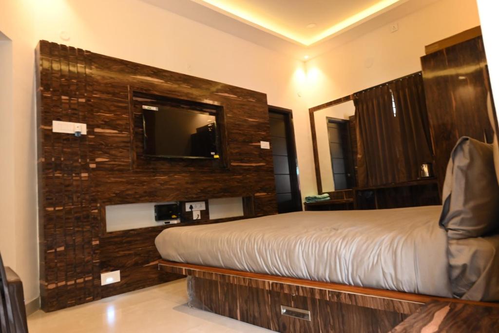 Pokój hotelowy z łóżkiem i lustrem w obiekcie Melody Inn w mieście Yercaud