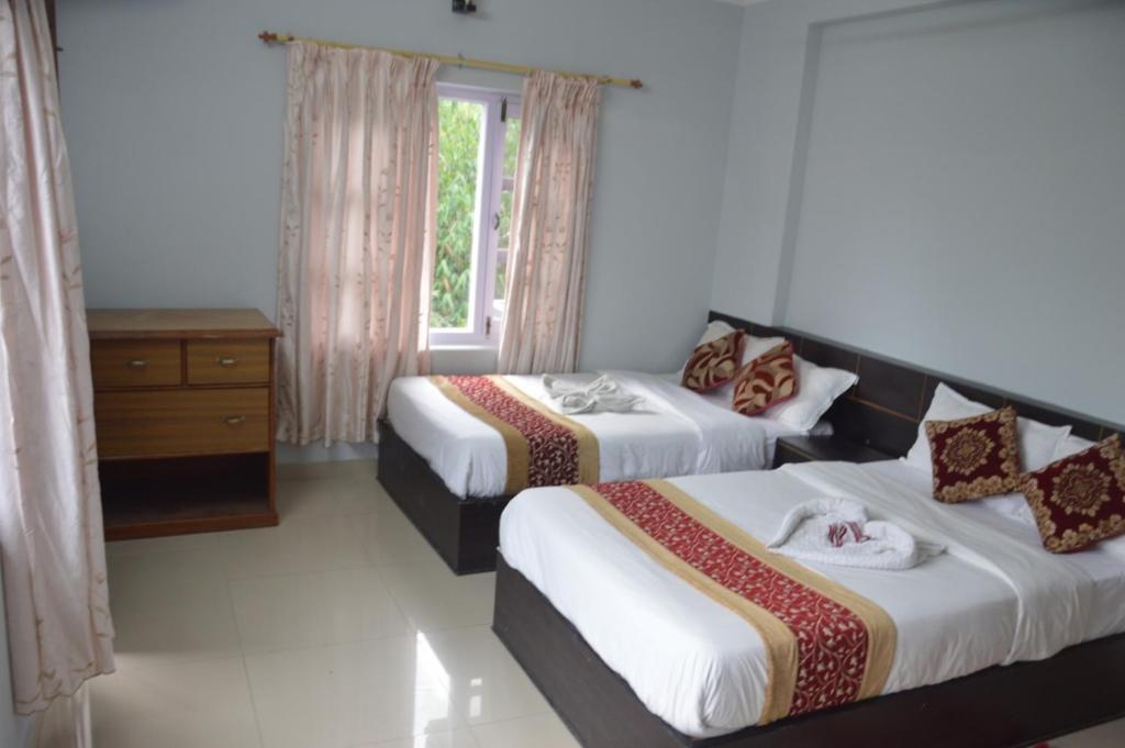 una camera d'albergo con due letti e una finestra di Hotel Blue moon Pokhara a Pokhara