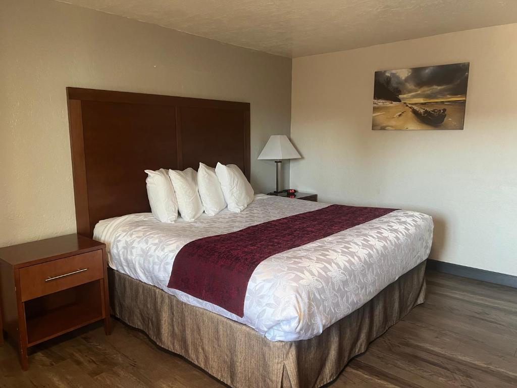 a hotel room with a large bed with white pillows at Red Carpet Inn Medford in Medford