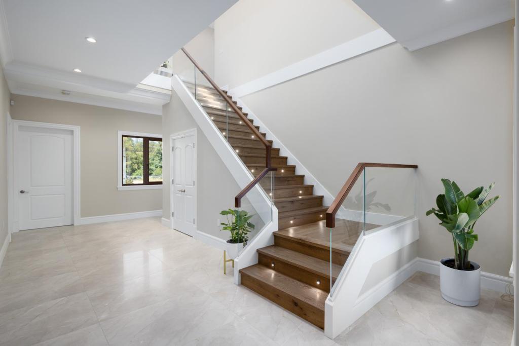 a staircase in a home with white walls and wooden stairs at Vancouver Vacation Home in Richmond