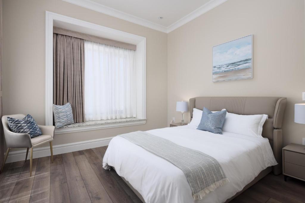 a white bedroom with a large bed and a window at Vancouver Vacation Home in Richmond