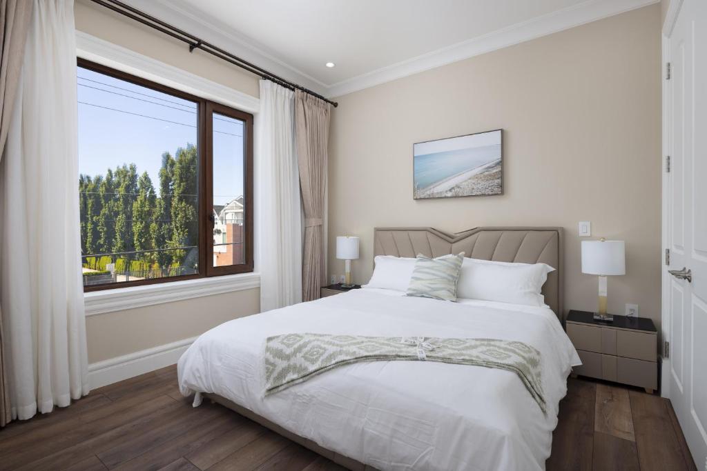 a bedroom with a bed and a large window at Vancouver Vacation Home in Richmond