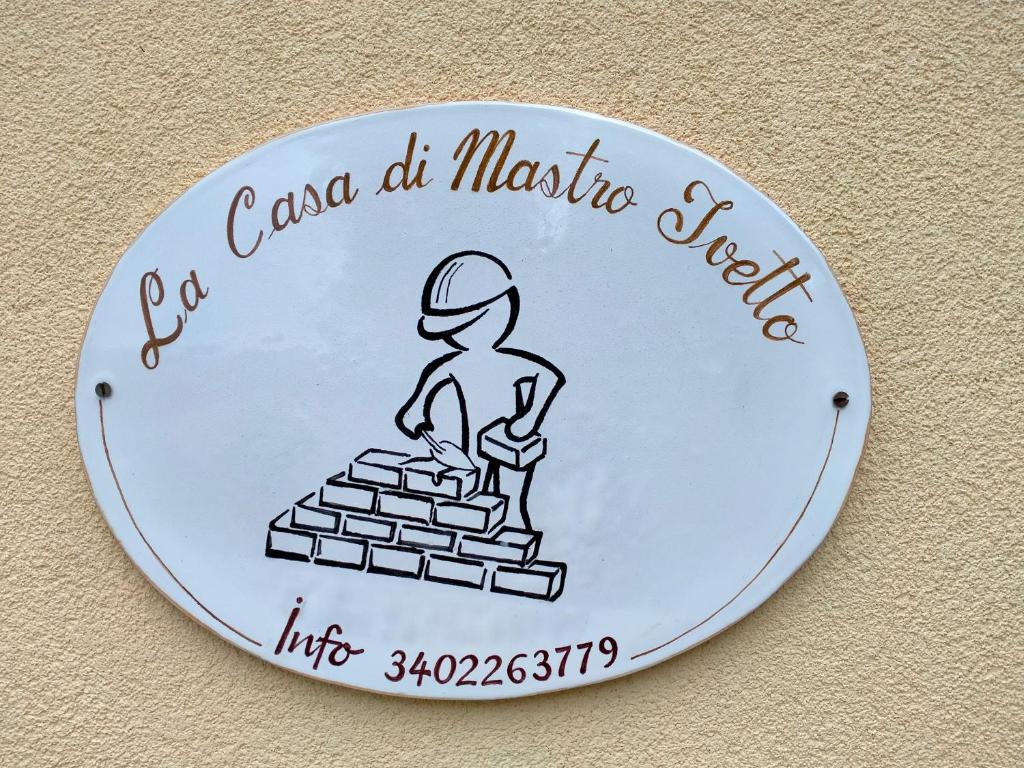 un signe avec un homme sur une pile de briques dans l'établissement La casa di Mastro Ivetto, à Arcevia