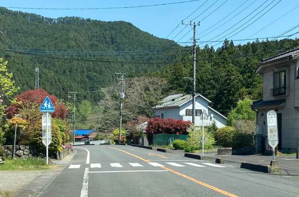 an empty street in a town with a mountain at 川辺-KAWABE-BBQ-川遊び-fishing in Hanno