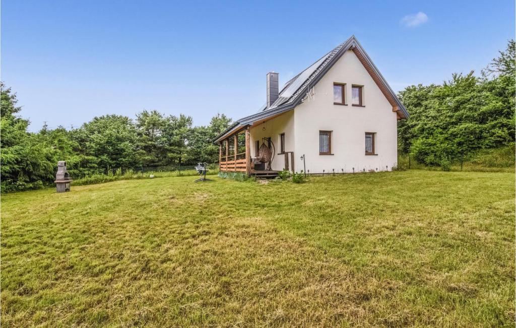 an old white house with a large grass field at 3 Bedroom Gorgeous Home In Nidzica in Nidzica