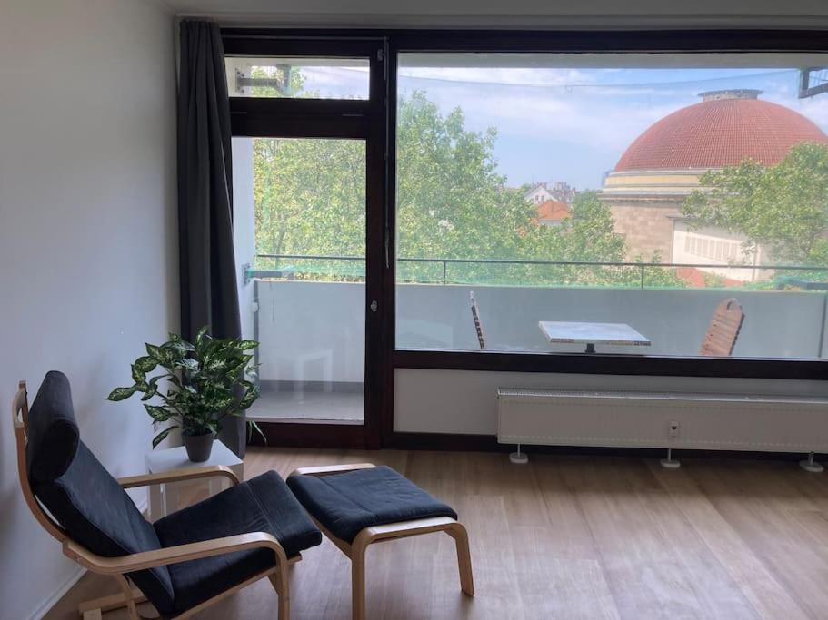sala de estar con ventana grande y silla en Über den Dächern von Offenbach, en Offenbach