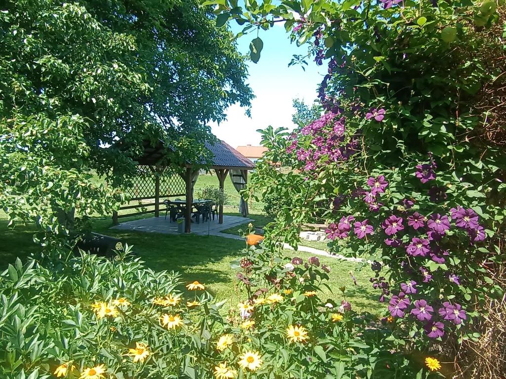 un jardín con una mesa de picnic y flores en Ostoja u Moni, en Stare Juchy
