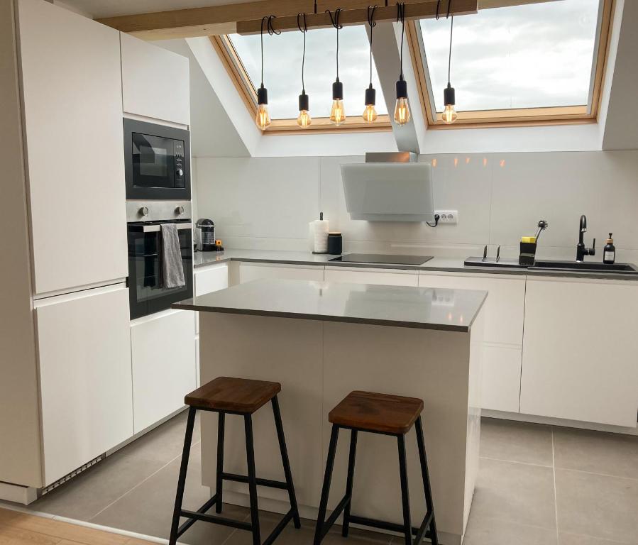 a kitchen with a counter and two stools at Agro Lux Apartment - Milenović in Soko Banja