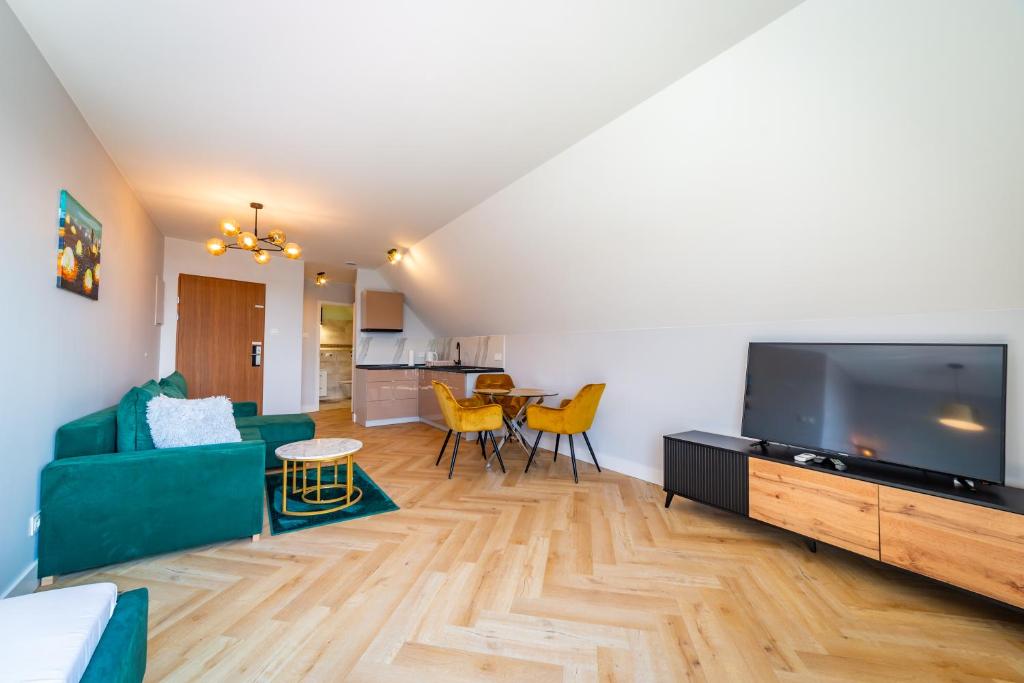 Televízia a/alebo spoločenská miestnosť v ubytovaní Apartamenty Mazurskie