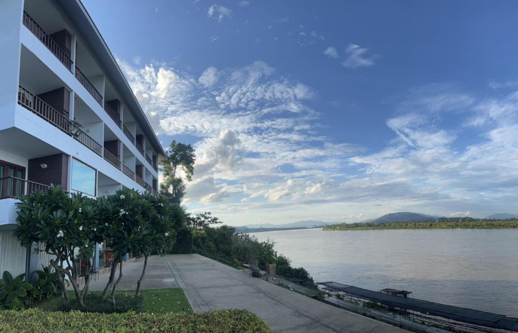 a building next to a body of water at Siam Triangle Hotel in Chiang Saen