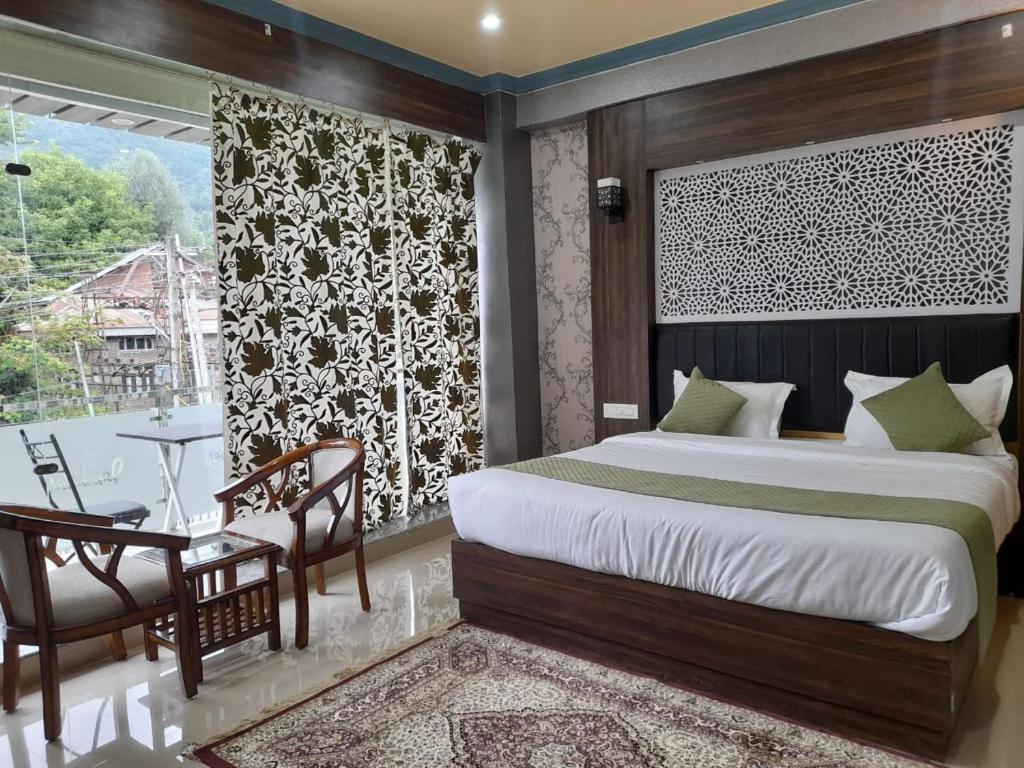 a bedroom with a bed and a table and a window at THE JAMAWAR in Srinagar
