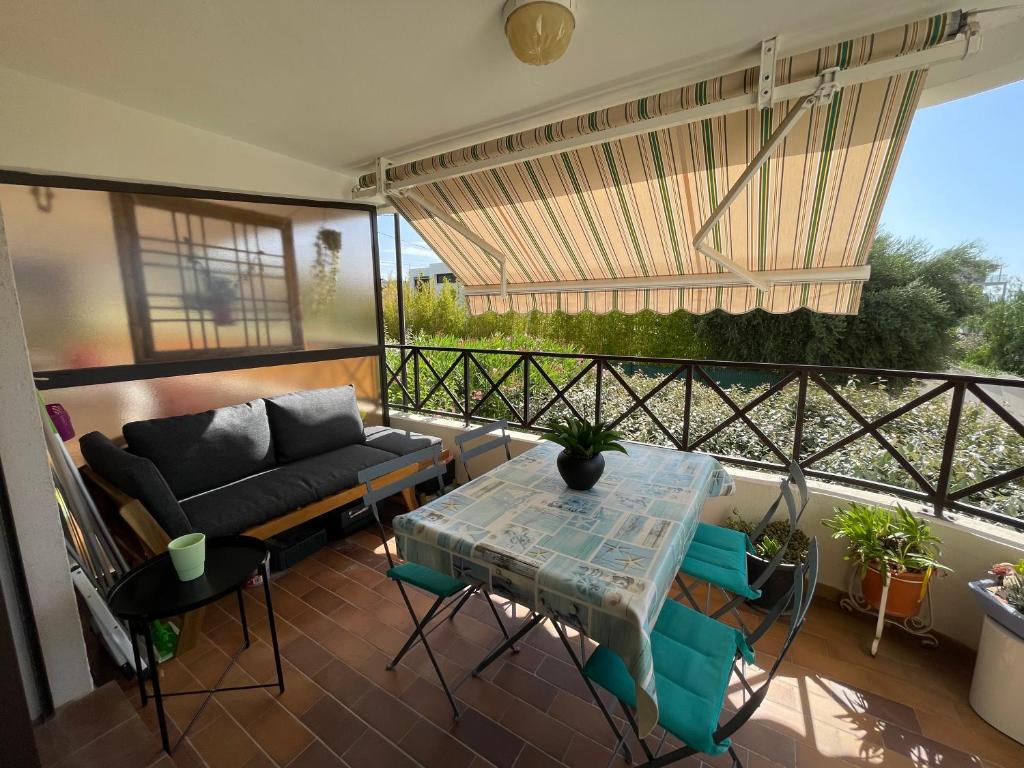 - un balcon avec un canapé et une table dans l'établissement Studio Bandol 4 couchages centre ville vue mer garage, à Bandol