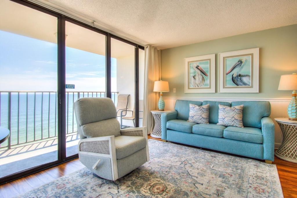 a living room with a couch and a chair at 1112 Relax Life Is Good by Atlantic Towers in Carolina Beach