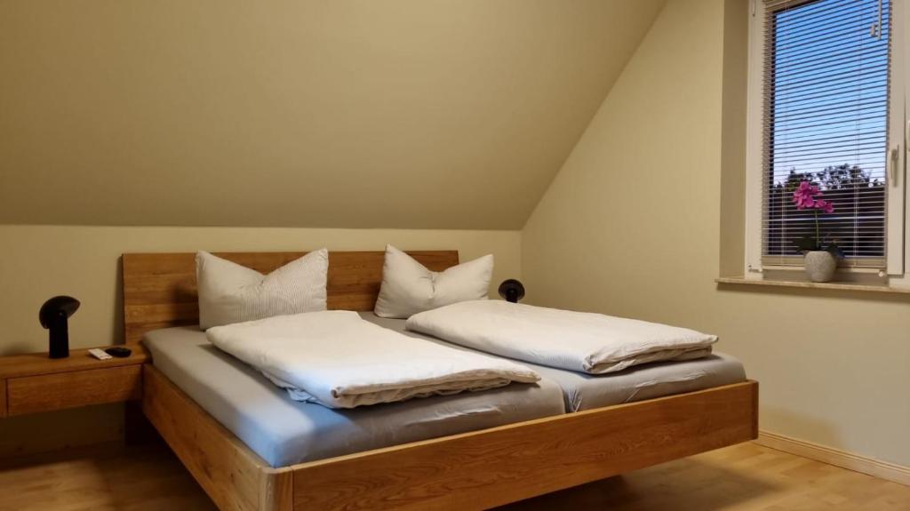 a bedroom with a bed with white sheets and a window at Suite Kleine Auszeit in Liepgarten