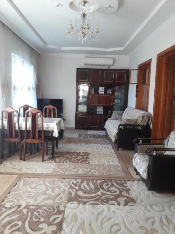 een woonkamer met een tafel en een bank bij Apartment at Narimanov 151 in Ganja