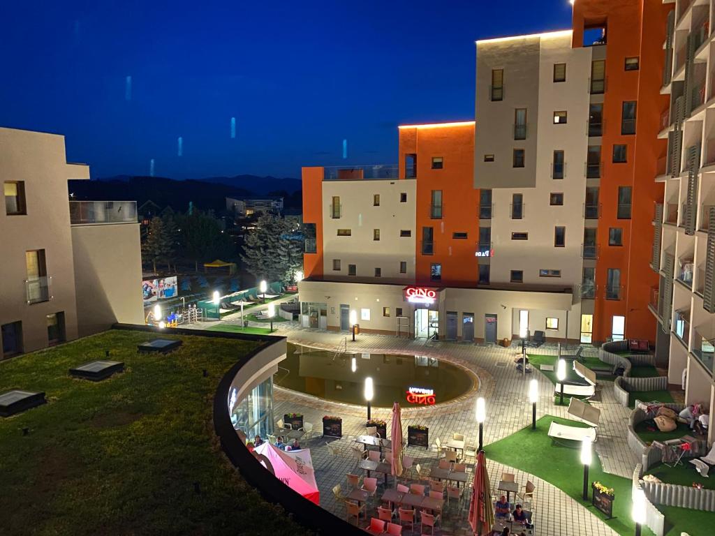 - une vue sur un bâtiment avec une cour la nuit dans l'établissement Apartment Family Besenova Aquapark, à Bešeňová