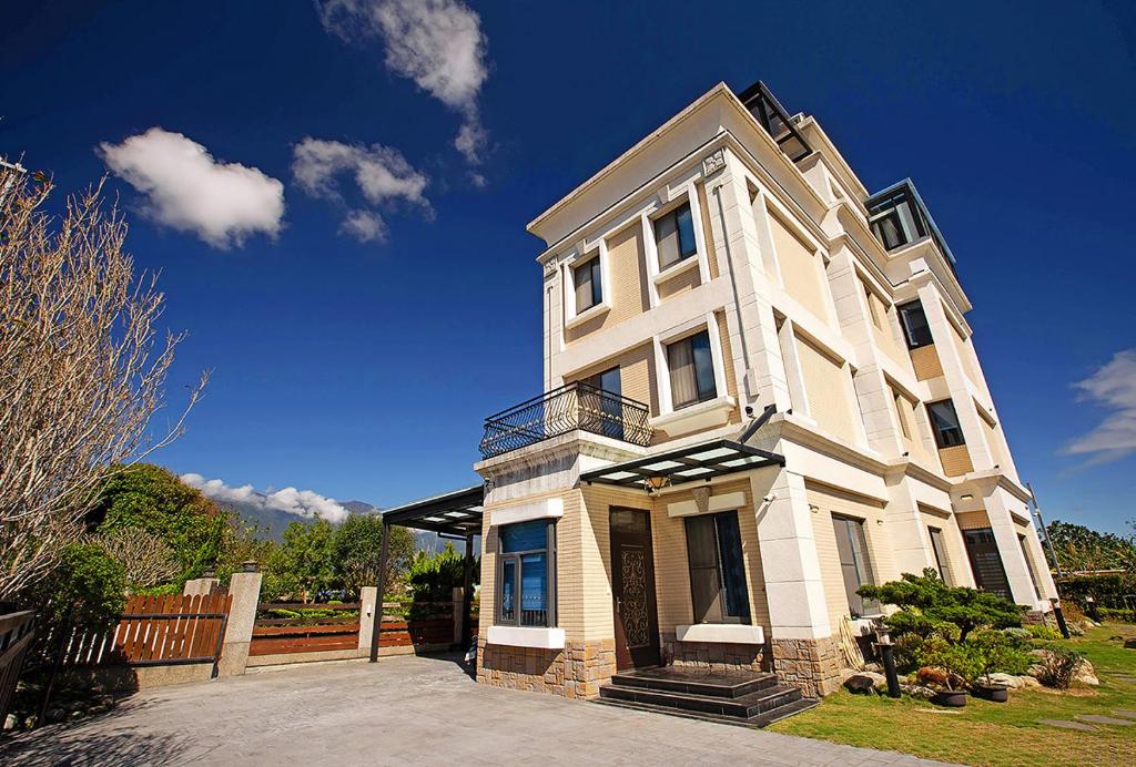 une grande maison blanche avec un ciel bleu dans l'établissement Moritz Homestay, à Hualien