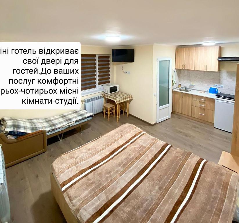 1 dormitorio con 1 cama grande y cocina en Petite Chambre en Velyatyn