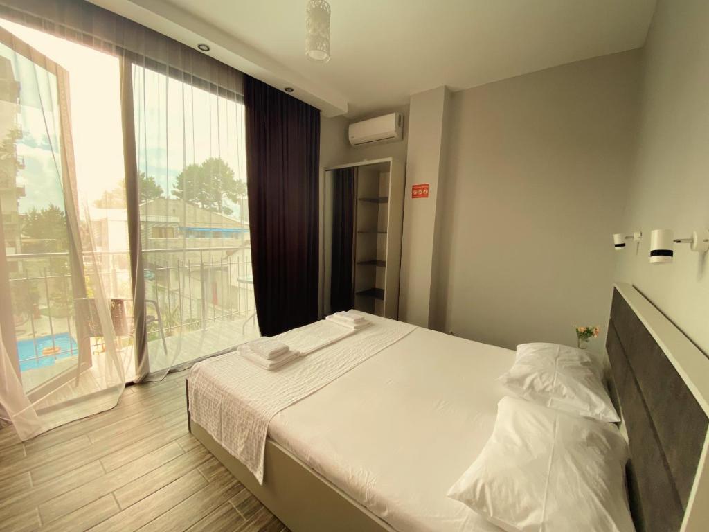 a bedroom with a bed and a large window at Hotel VS in Kobuleti