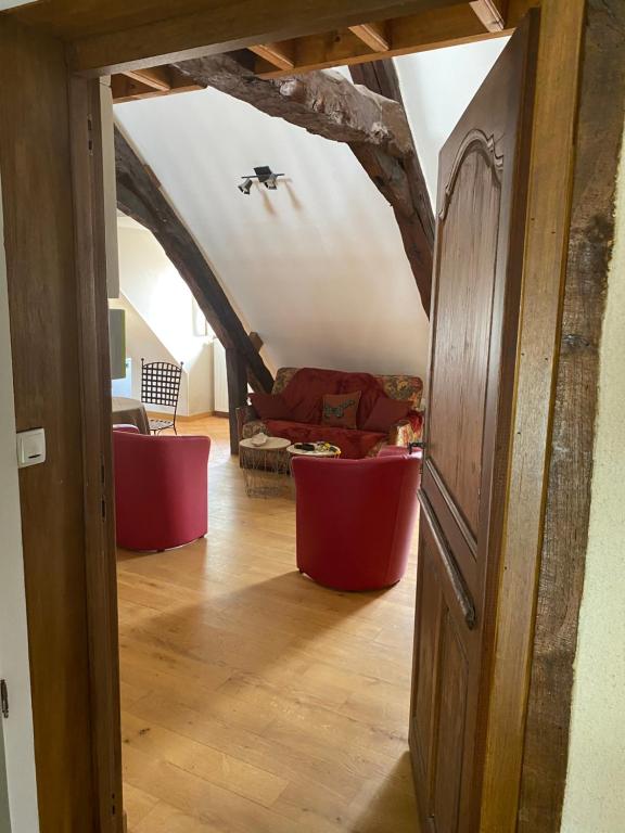 een hal met een woonkamer met een rode bank bij Loft duplex de charme 8 p plein centre in Lisieux