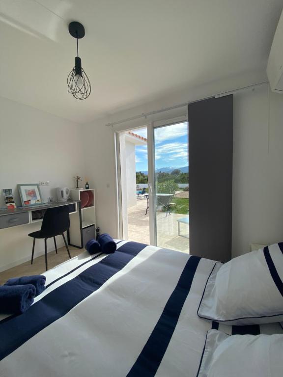 Schlafzimmer mit einem Bett, einem Schreibtisch und einem Fenster in der Unterkunft Villa Vittoria in Ghisonaccia