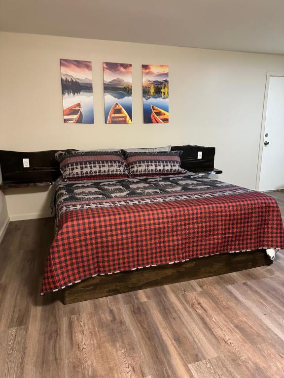 a bed with a plaid blanket and pillows in a room at Crater Lake Gateway - Hwy 140 in Klamath Falls